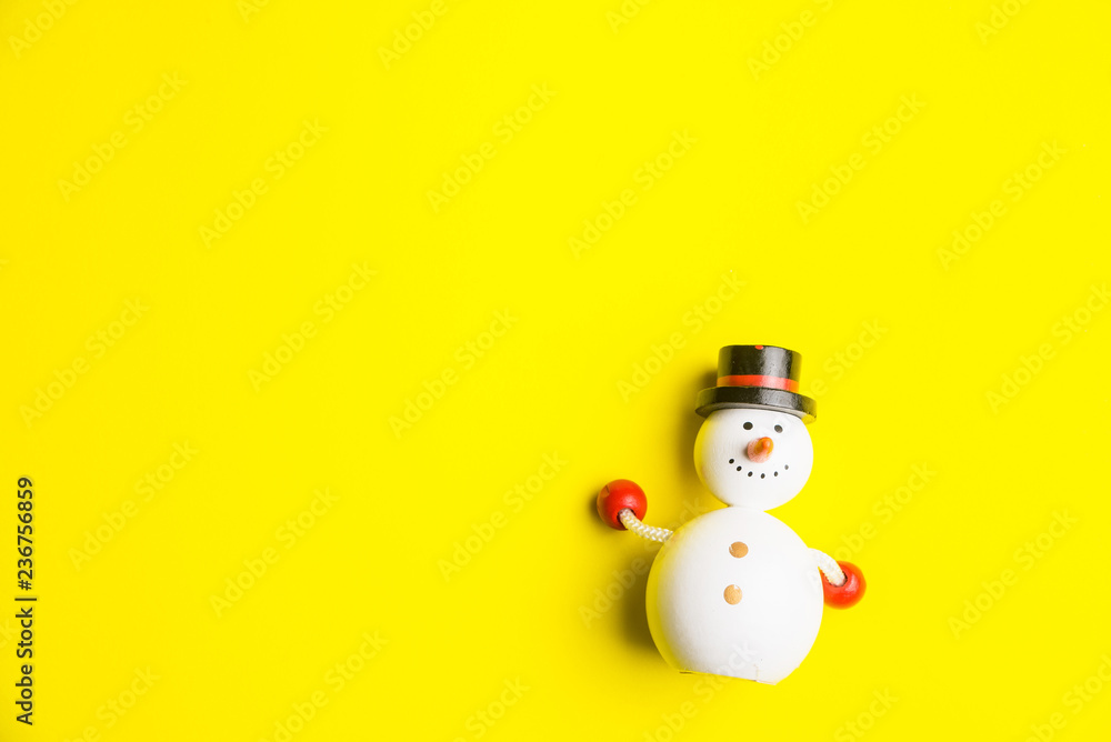 Small snowman isolated on yellow background at Christmas day.Theme Christmas day background.