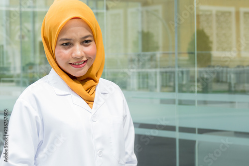 Confident female doctor standing infront of  office and smiling at camera, health care and prevention concept © tuahlensa