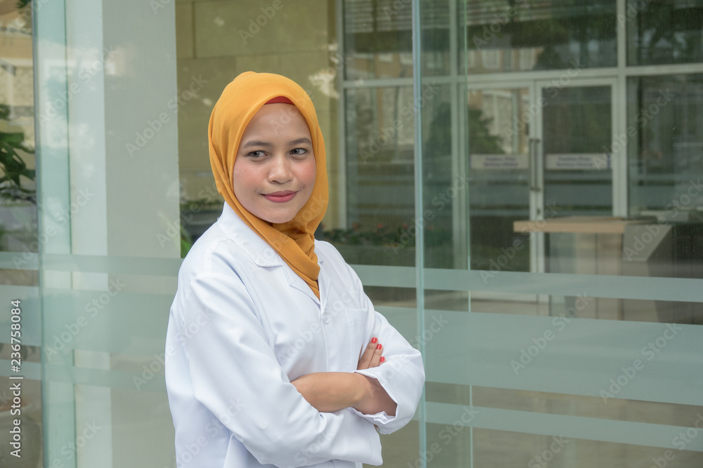 Confident female doctor standing infront of  office and smiling at camera, health care and prevention concept