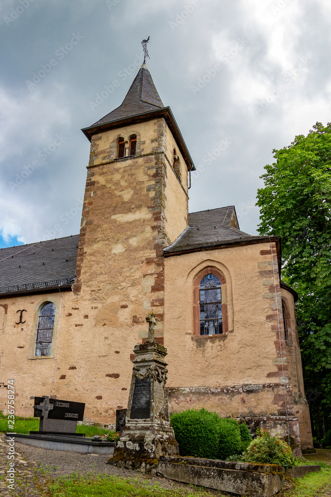 Church of St. Peter in Roth an der Our, Germany - a former church of the Knights Templar, partial summer exterior view under dramatic overcast sky