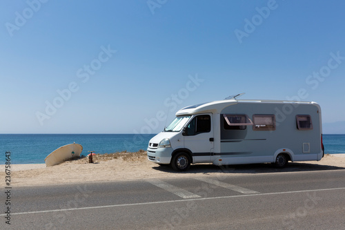 Moderna autocaravana acampada en la arena de la playa.