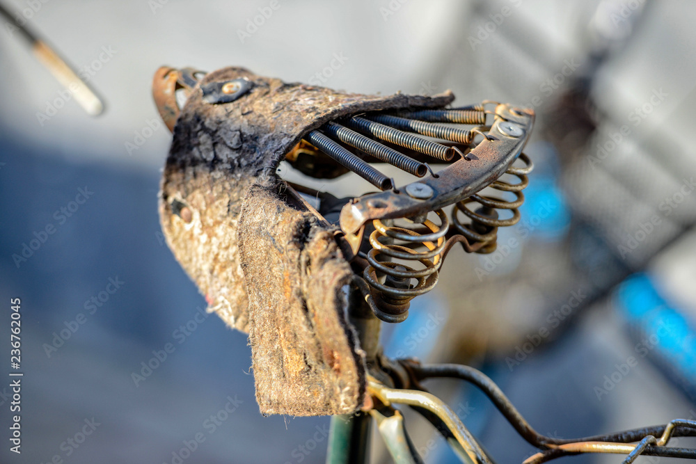 Close-up photography. The old bicycle seat is damaged.