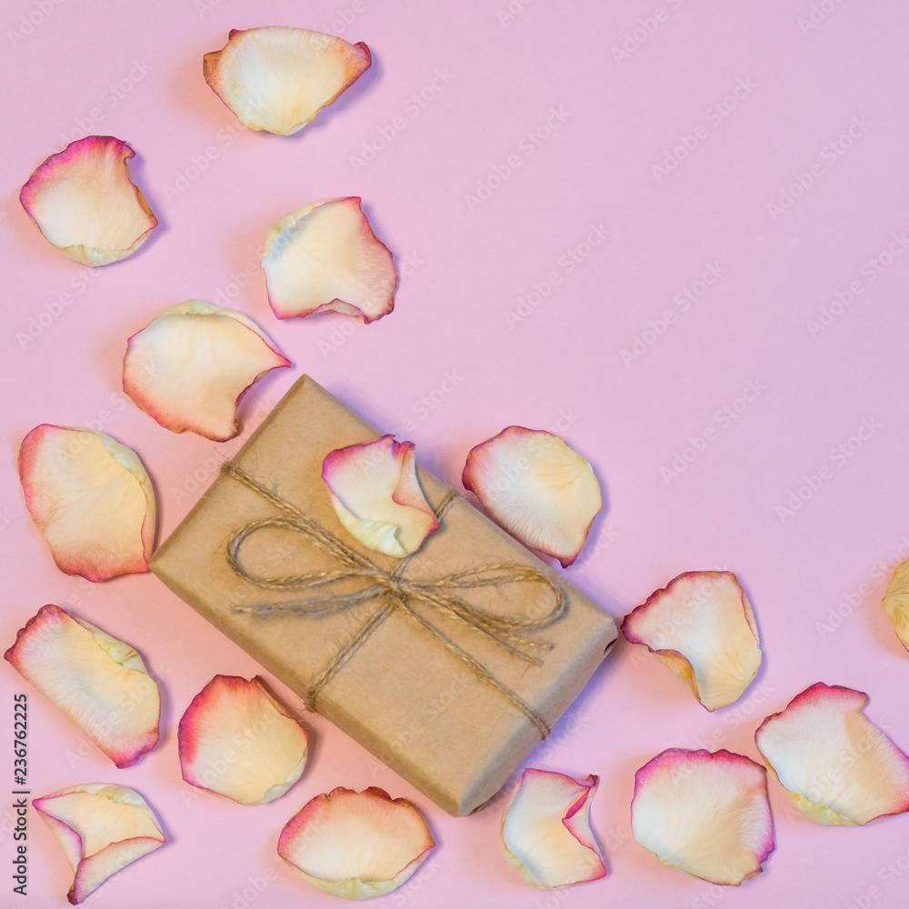 Gift box wrapping in kraft paper with dried cream rose petals on Gift box wrapping in kraft paper with dried cream rose petals on