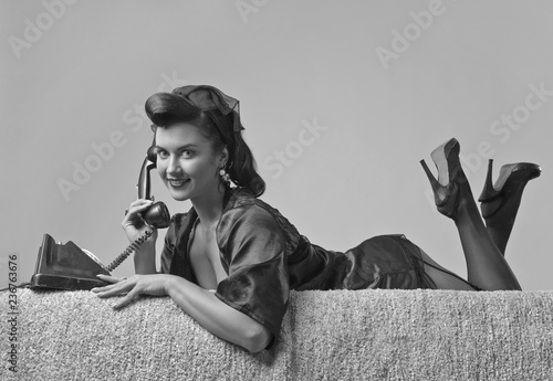 Foto Beautiful woman speaking via vintage phone.