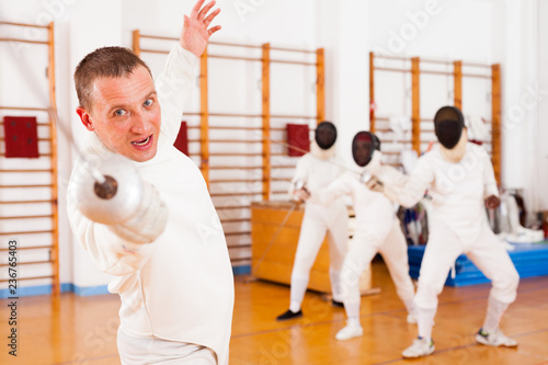 Sporty young man fencer practicing effective fencing techniques