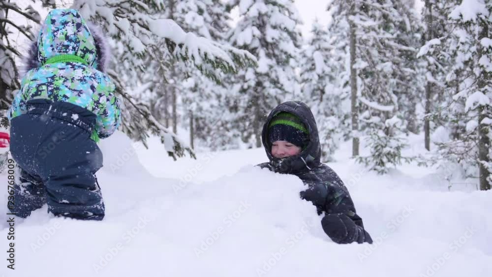 Children in the Park playing with snow. Laughter and joy from the first snow.Snowfall. Walking in the fresh air. Healthy lifestyle Children in the Park playing with snow. Laughter and joy from the first snow.Snowfall. Walking in the fresh air. Healthy lifestyle