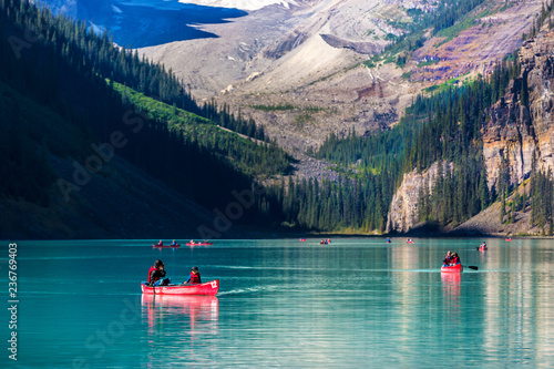 Banff, Canada - Sept 17th 2017 - A family doing kayak at the Lake Louise with pine trees in the background at the Banff National Park in Canada