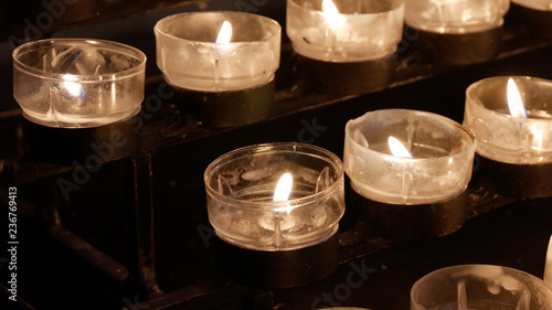 Close up burning lit candles / tealights in Catholic Christian Church photo