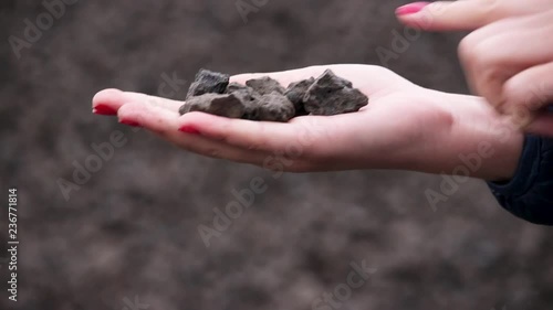 Crushed stone. On the hand are waste from the metallurgical plant. small pieces. Female hand.