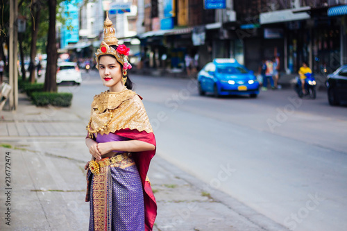 Woman wearing Thai style dress standing on the footpath in Bangkok, Thailand. © MPIX.TURE