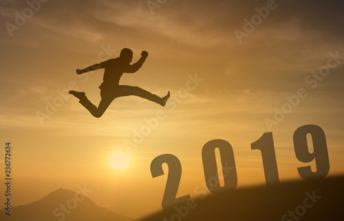 2019 brave man successful concept,silhouette man jumping over the sun between gap of the mountain to 2019 new year, feel like a winner, success, finish,reach a goal of live,jobs,work in year coming