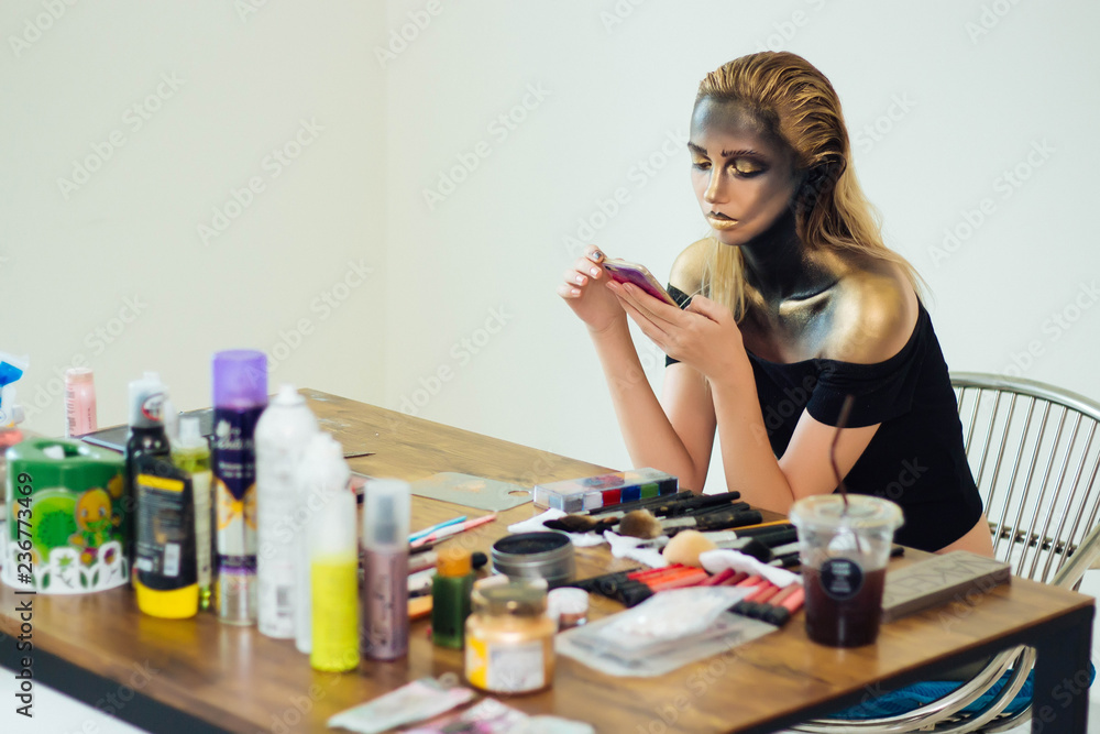 Model is playing mobile phone during a break and waiting for a makeup artist. Model is playing mobile phone during a break and waiting for a makeup artist.