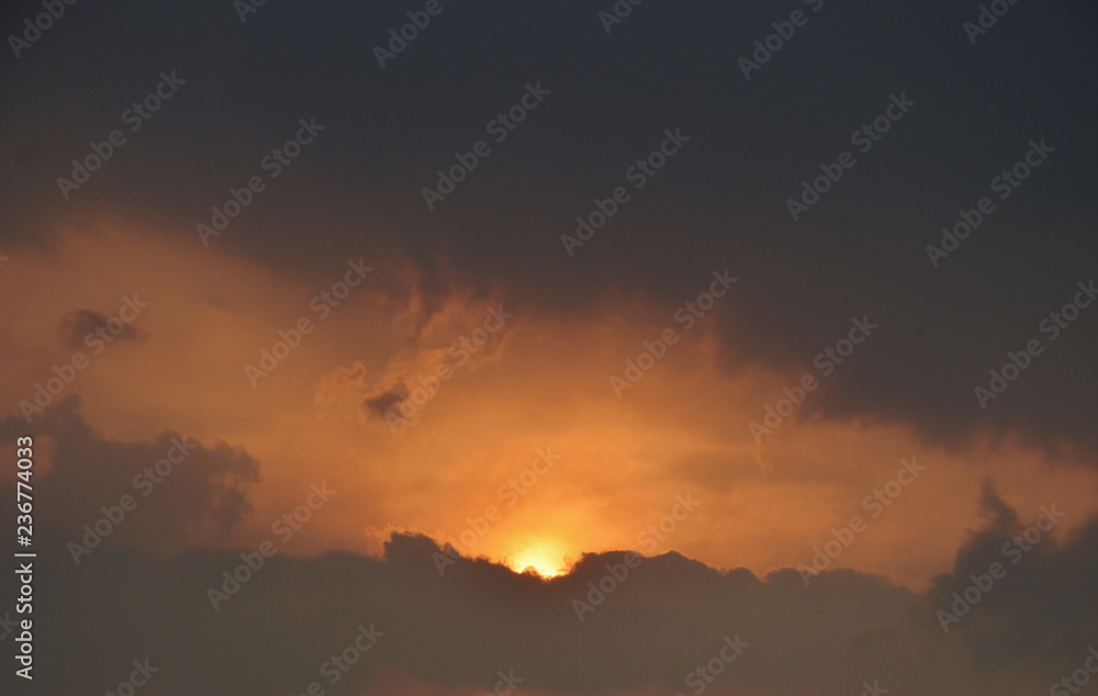 sun down behind big gray cloud in evening sun down behind big gray cloud in evening