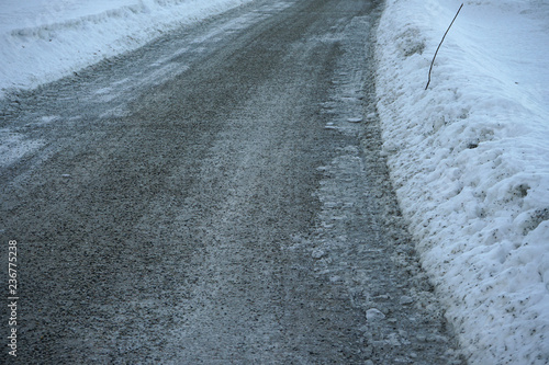 Local road in winter time covered with small stones.