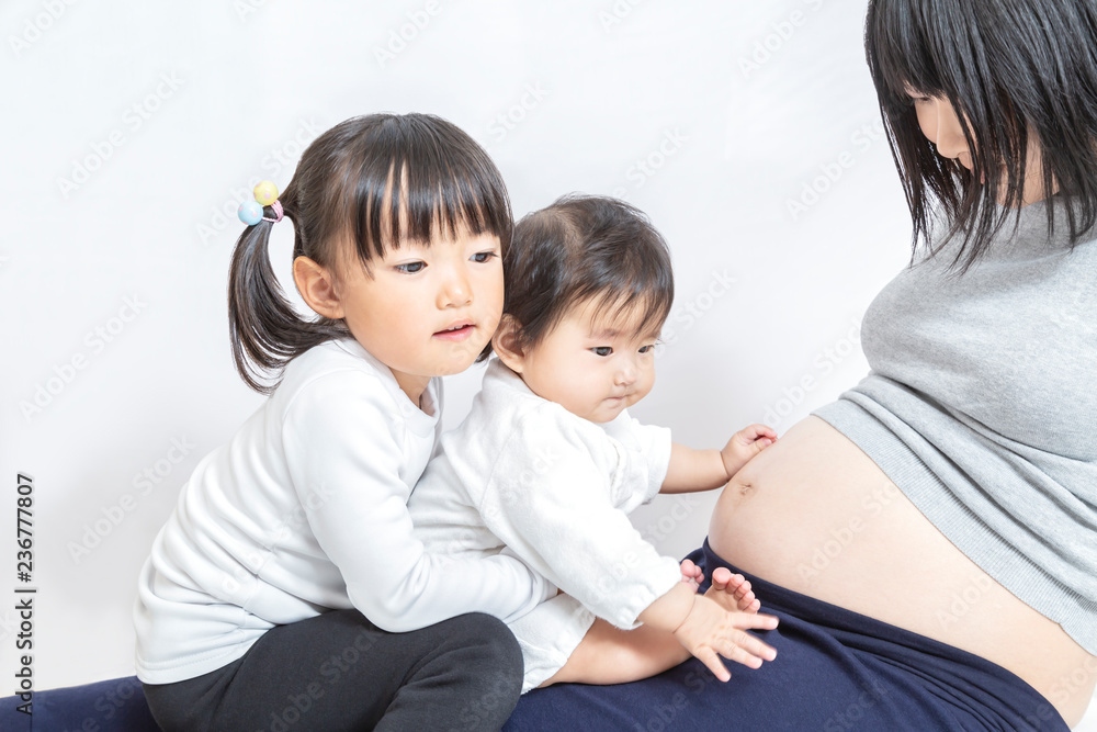 お母さんの妊娠した大きなお腹を前に遊ぶ赤ちゃんと幼い女の子 親子 家族 妊娠 妊婦 愛 幸せイメージ Stock Photo Adobe Stock