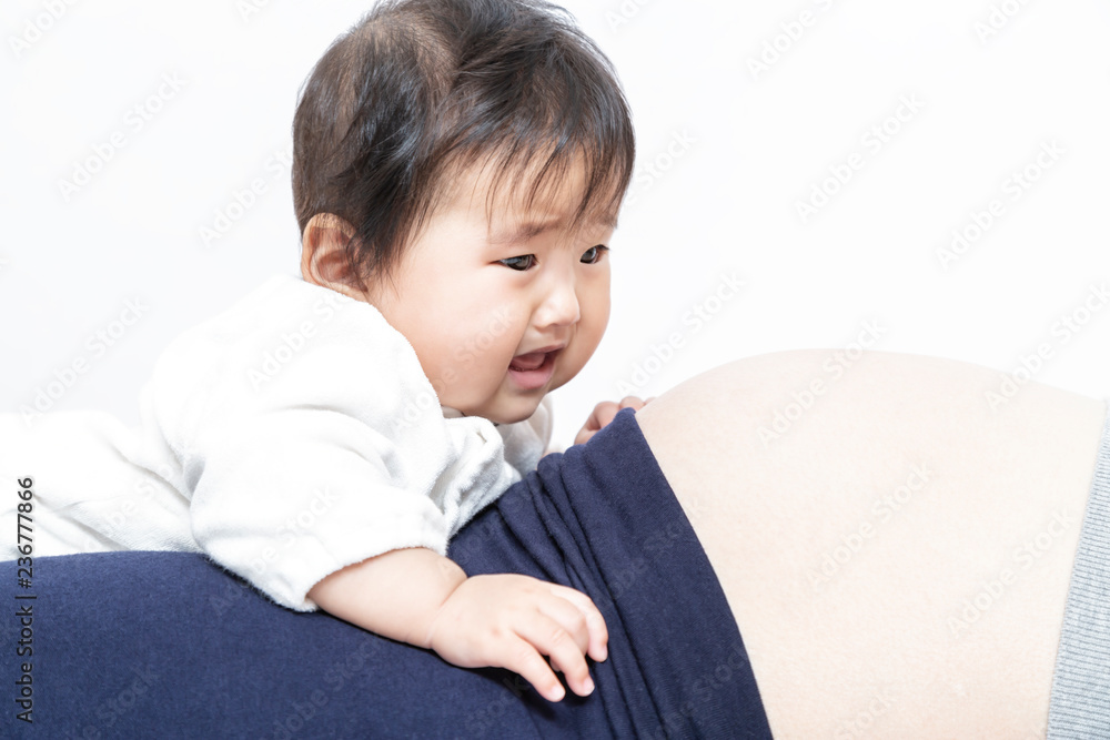 お母さんの妊娠した大きなお腹に乗る赤ちゃん。家族、妊娠、子供、赤ちゃん、年子イメージ