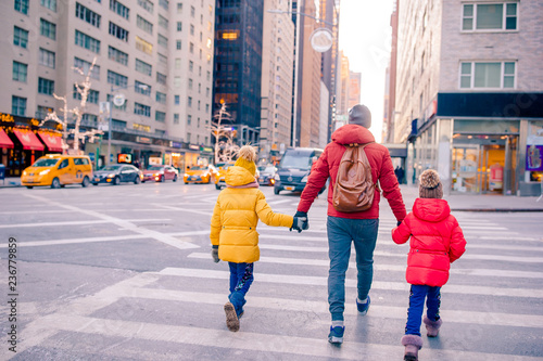 Family of father and little kids on Times Square during their vacation in New York City