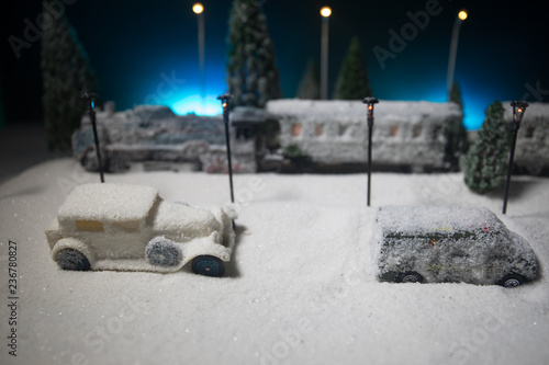 Miniature of winter scene with Christmas houses, train station, trees, covered in snow. Nights scene. New year or Christmas concept.