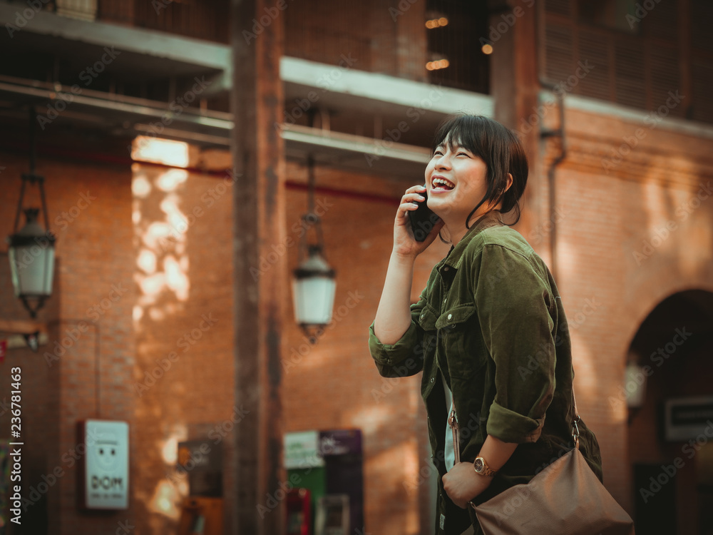 Fototapeta premium Asian woman using smartphone with happy mood in shopping mall