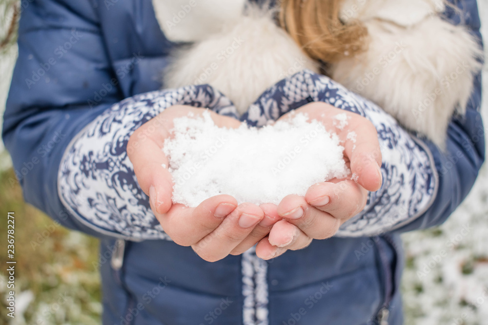 Snow on the palm in the hands of a little girl for design background Snow on the palm in the hands of a little girl for design background