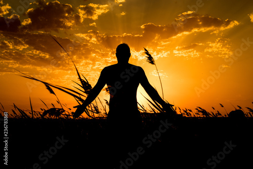 Silhouette of man with their hands in the sunset. Outdoor shot