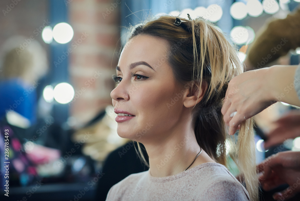 Young european woman is getting hair style service in a beauty shop. Young european woman is getting hair style service in a beauty shop.