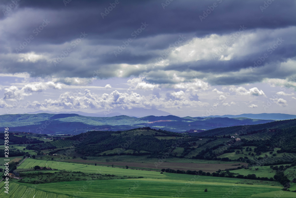 Panoramic view of the italian tuscany. The mountains in the distance are covered by clouds.