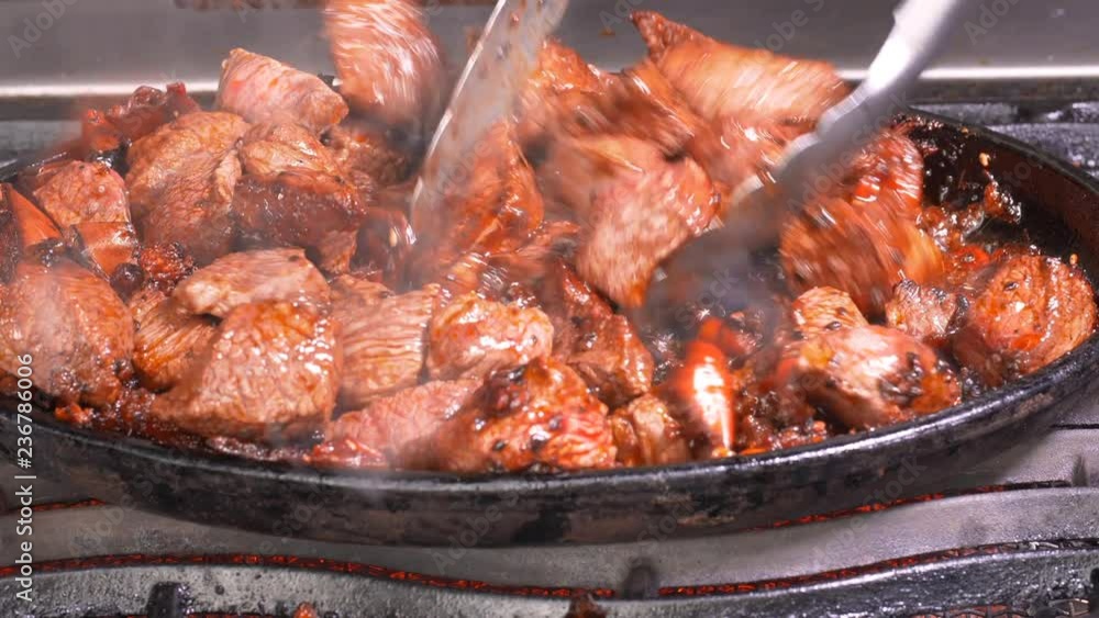UHD closeup shot of the delicious beef frying with hot red peppers, peanuts and soy sauce