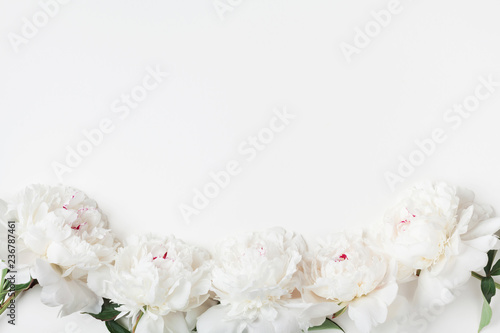 Fototapeta Naklejka Na Ścianę i Meble -  Empty notebook and gift or present box decorated white peony flowers on pastel table top view. Flat lay composition for birthday or wedding.