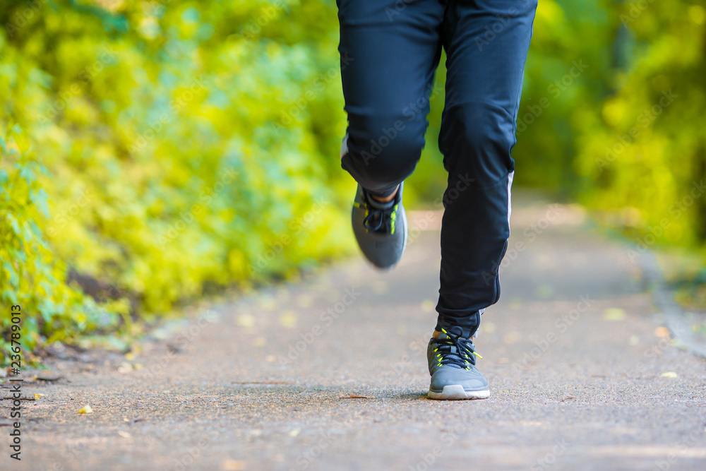 Close-up on shoe of athlete runner man feet running on road Close-up on shoe of athlete runner man feet running on road