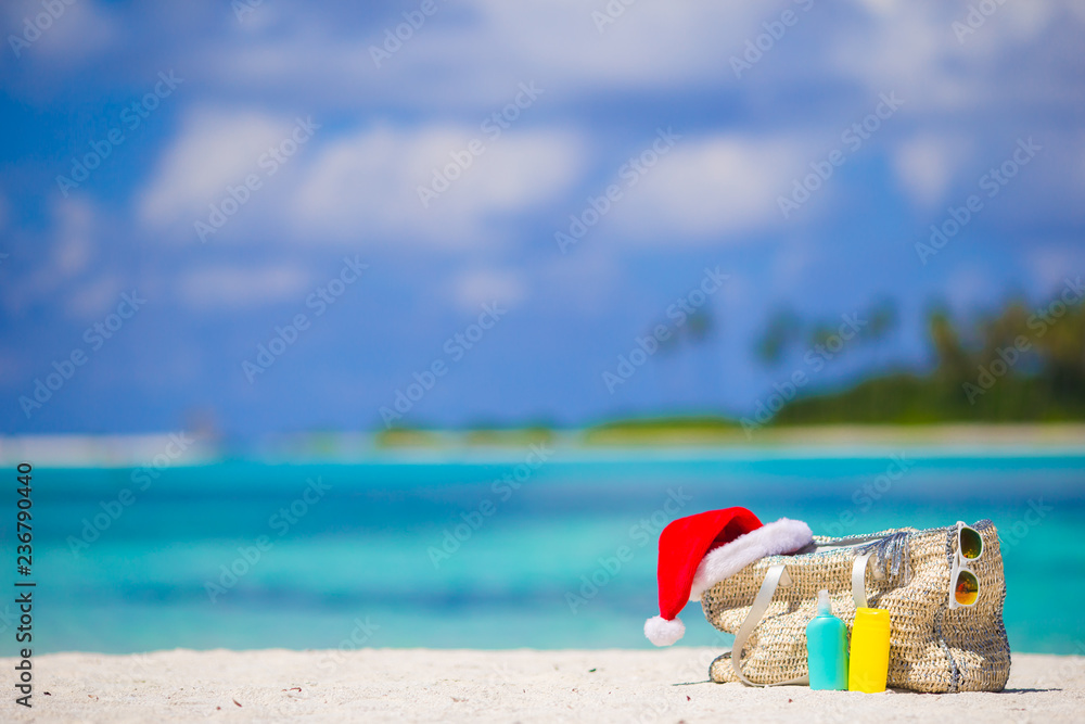 Beach accessories with Santa Hat on white tropical beach Beach accessories with Santa Hat on white tropical beach