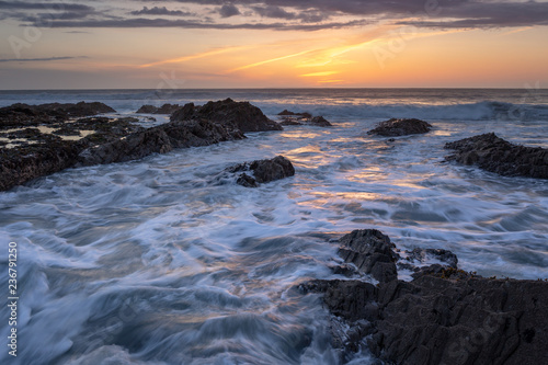 Westward Ho! seascape sunset with waves crashing around the rocks with golden sky