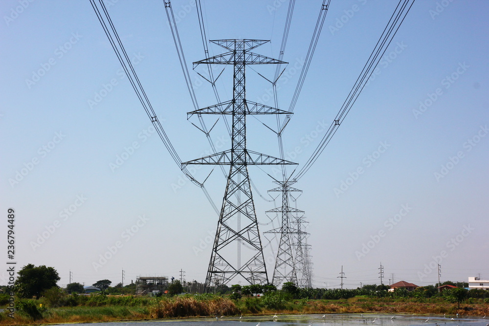 the high voltage electric pole pass in country side witj bluesky background