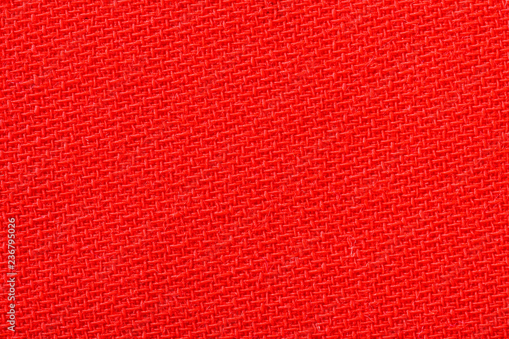 Red fabric background texture. Detail of textile material close-up