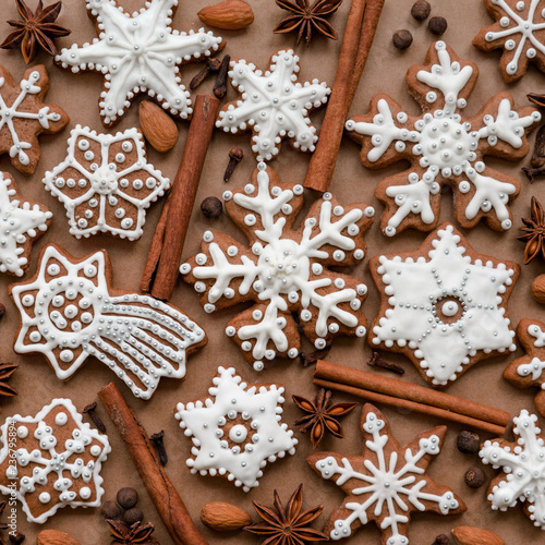 Fototapeta Naklejka Na Ścianę i Meble -  Christmas dekoration with spices and cookies in the shape of snowflakes, cinnamon sticks and star anise on dark brown paper background. Top view.