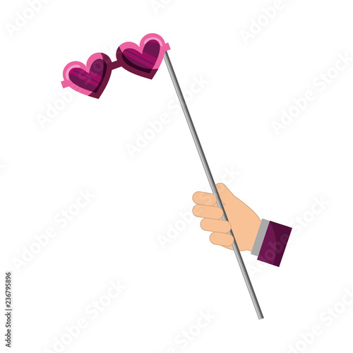 hand with glasses with heart shaped lens in stick