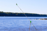 Fishing on feeder, feeder gear against the background of a blurred river and forest.