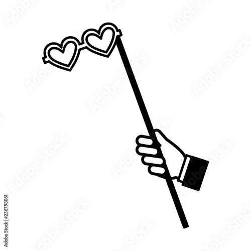 hand with glasses with heart shaped lens in stick