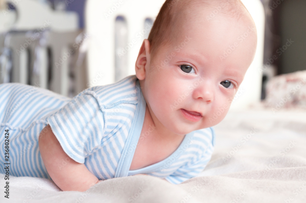 Cute baby is lying on the bed and learning to hold his head. Cute baby is lying on the bed and learning to hold his head.