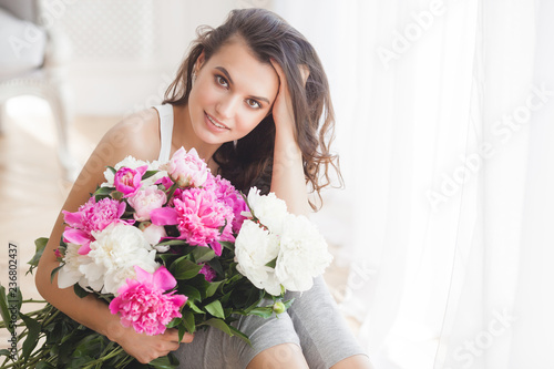 Beautiful woman holding flowers. Young lady with peony