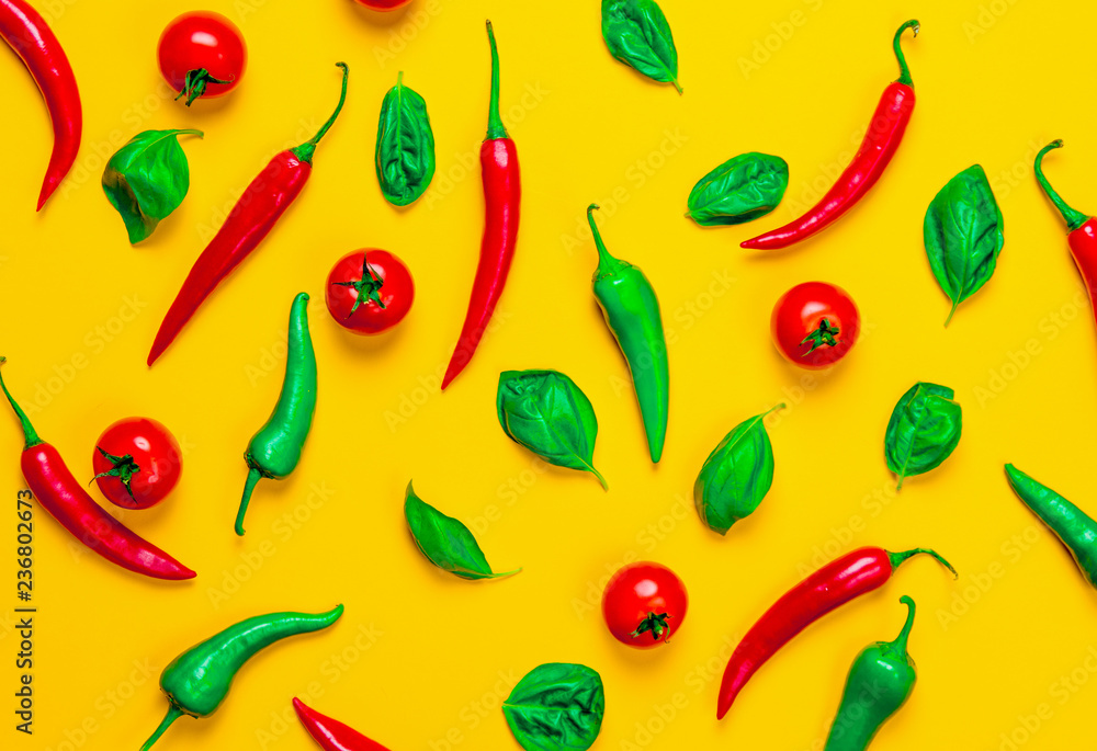 Above view at Chili pepper and tomatoes with basil on yellow background Above view at Chili pepper and tomatoes with basil on yellow background