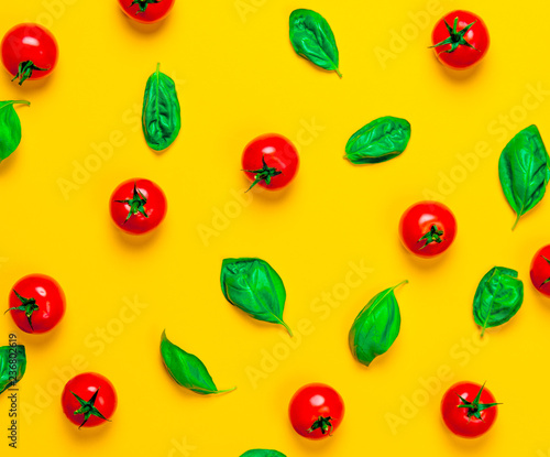Wallpaper Mural Above view at tomatoes and basil on yellow background Torontodigital.ca