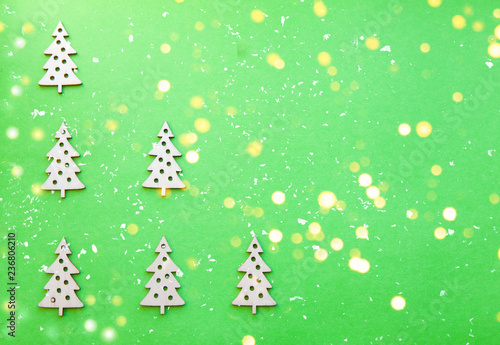 New Year wooden ornaments, top view. Wooden Christmas tree. Green background. Flat lay style.
