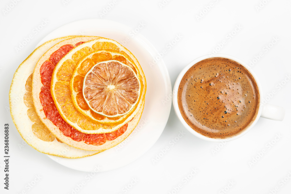 Dried slices of various citrus fruits and black coffee in a white Cup Dried slices of various citrus fruits and black coffee in a white Cup