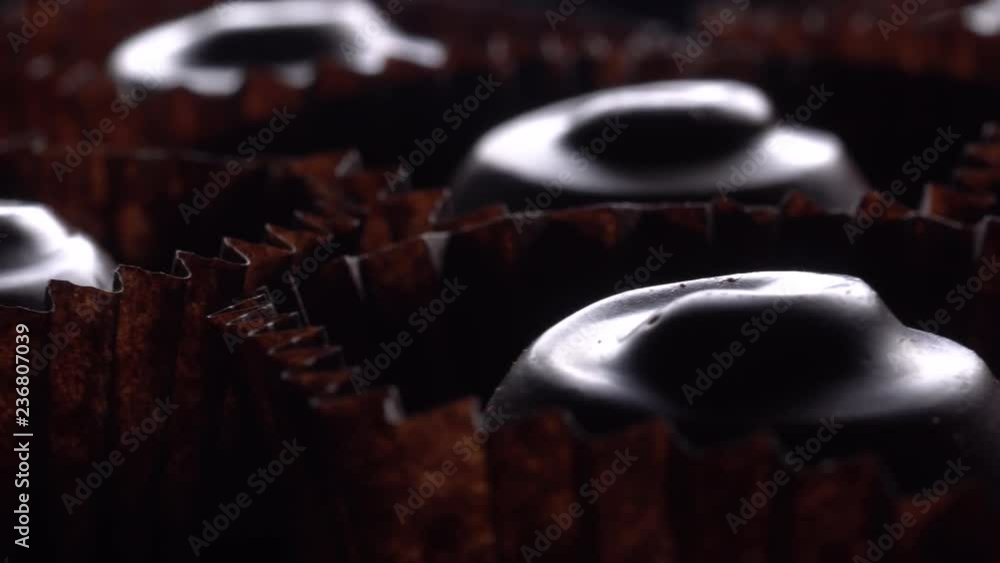 Chocolate bonbons in rotation on a black background, Closeup. Chocolate bonbons in rotation on a black background, Closeup.