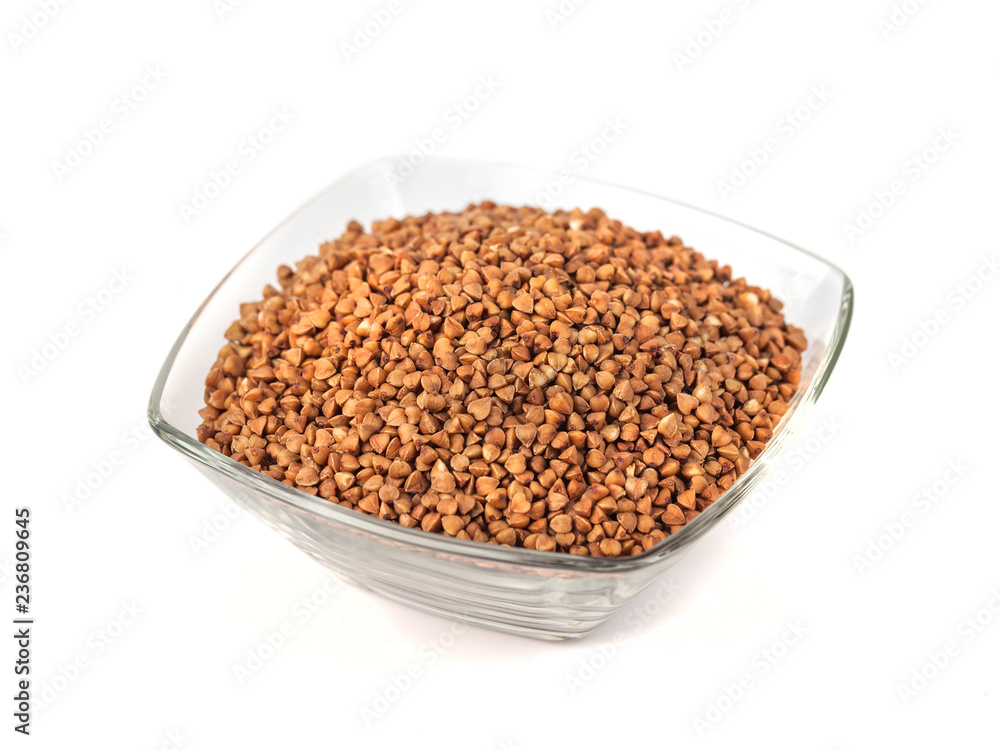 Roasted buckwheat grains in glass bowl isolated on white background Roasted buckwheat grains in glass bowl isolated on white background