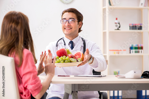 Pregnant woman visiting doctor discussing healthy diet