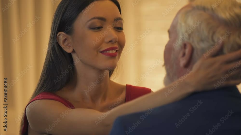 Sexy young lady flirting with old business man, hugging him, escort service Sexy young lady flirting with old business man, hugging him, escort service