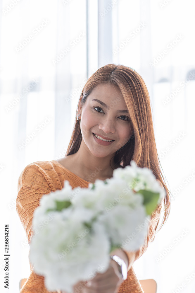Beautiful Asian woman smile and holding flower or bouquet feeling so happiness and cheerful