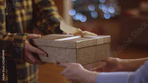 Man gives a Xmas present to woman, faceless shot